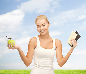 Image showing sporty woman with apple and chocolate bars
