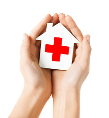 Image showing hands holding paper house with red cross