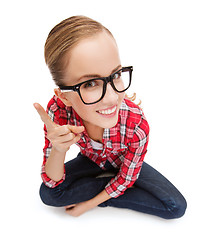 Image showing smiling teenager in eyeglasses with finger up