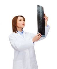 Image showing serious female doctor looking at x-ray
