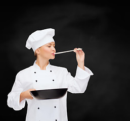 Image showing smiling female chef with pan and spoon