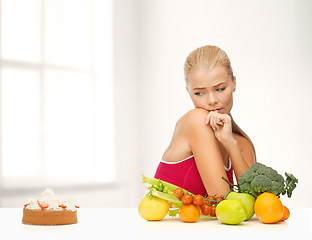 Image showing doubting woman with fruits and pie