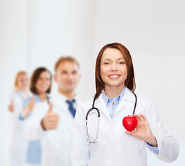 Image showing smiling female doctor with heart and stethoscope