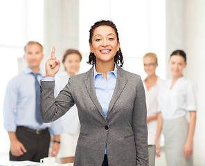 Image showing smiling businesswoman with her finger up at office