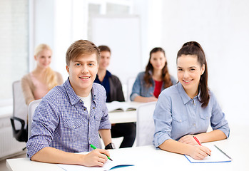 Image showing smiling students with notebooks at school