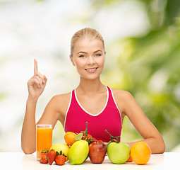 Image showing woman with juice and fruits holding finger up