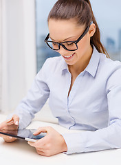 Image showing smiling businesswoman in eyeglasses with tablet pc