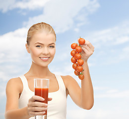 Image showing woman holding glass of juice and tomatoes