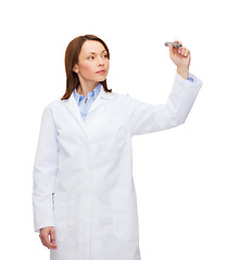 Image showing young female doctor writing something in the air