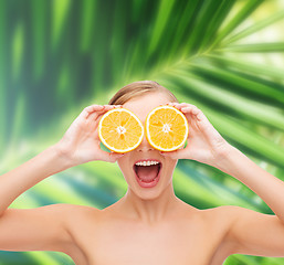 Image showing amazed young woman with orange slices