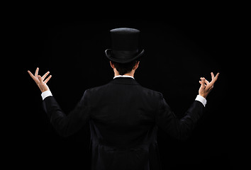 Image showing magician in top hat showing trick from the back