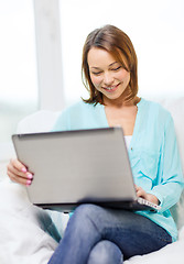 Image showing smiling woman with laptop computer at home