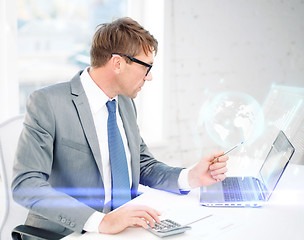 Image showing businessman with computer, papers and calculator