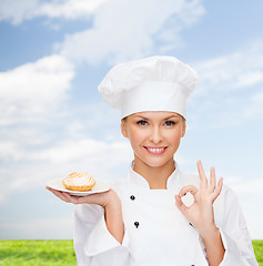 Image showing smiling female chef with cake on plate