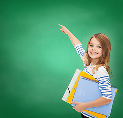 Image showing cute girl with folders pointing at virtual screen