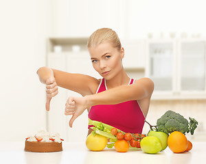 Image showing woman with fruits showing thumbs down to cake