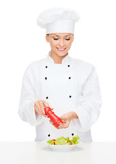 Image showing smiling female chef with preparing salad