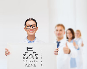 Image showing female doctor in eyeglasses with eye chart