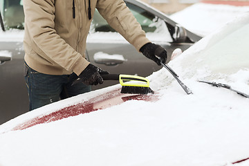 Image showing closeup of man cleaning snow from car