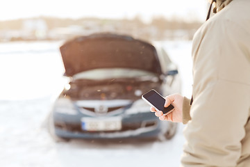 Image showing closeup of man with broken car and smartphone
