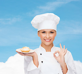 Image showing smiling female chef with cake on plate