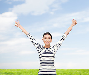 Image showing smiling girl in casual clother showing thumbs up