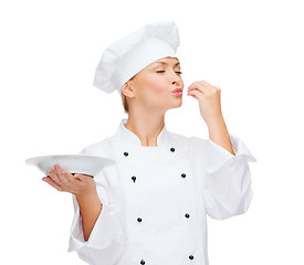 Image showing female chef with plate showing delicious sign