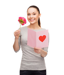Image showing smiling woman with postcard and flower