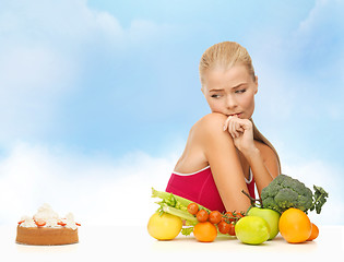 Image showing doubting woman with fruits and pie