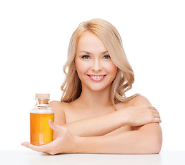 Image showing happy woman with oil bottle