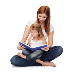 Image showing happy mother with adorable little girl and book