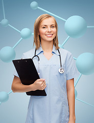 Image showing smiling female doctor or nurse with clipboard