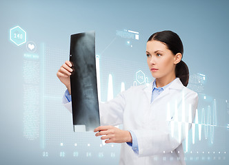 Image showing serious female doctor looking at x-ray