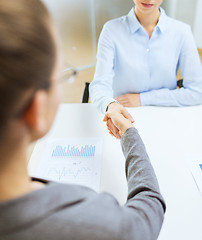 Image showing two calm businesswoman shaking hands in office