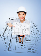 Image showing businesswoman in helmet showing with blueprint