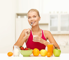 Image showing young woman eating healthy breakfast