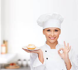 Image showing smiling female chef with cake on plate