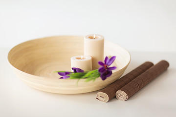 Image showing candles and iris flowers in wooden bowel and mat