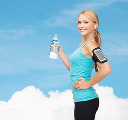 Image showing sporty woman running with smartphone and earphones