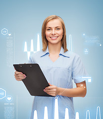 Image showing smiling female doctor or nurse with clipboard