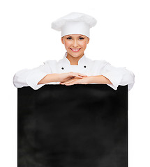 Image showing smiling female chef with white blank board