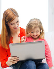 Image showing happy mother and daughter with laptop computer