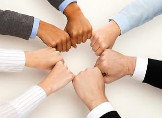 Image showing closeup of businesspeople hands in fists in circle