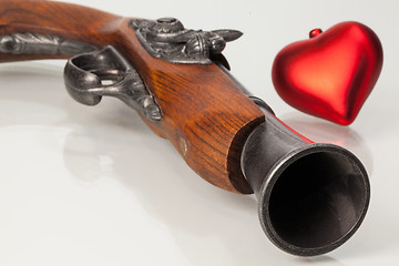 Image showing Old gun and red heart