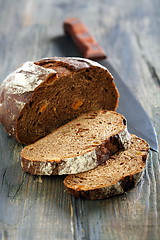 Image showing Rye bread with dried apricots and a knife.