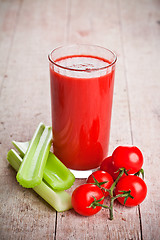 Image showing tomato juice in glass, fresh tomatoes and green celery 