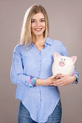 Image showing Beautiful woman holding  a piggy bank