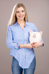 Image showing Beautiful woman holding  a piggy bank