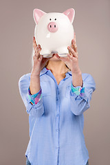 Image showing Beautiful woman holding  a piggy bank