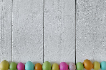 Image showing Easter or Spring Themed Background of Old Wood and Colored Eggs 